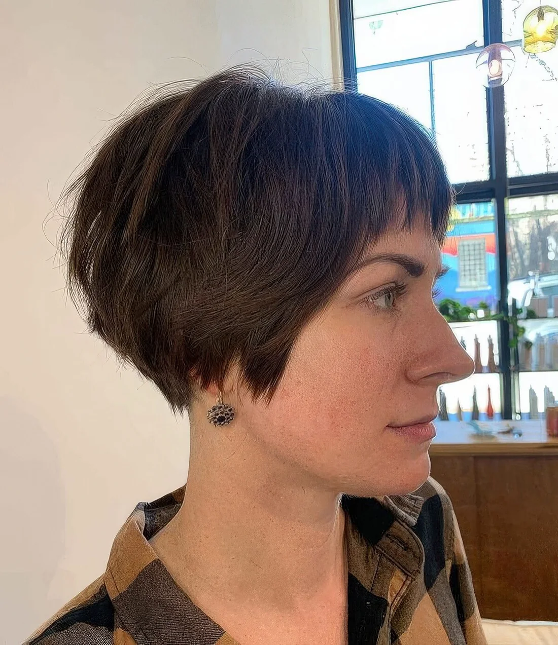 Brunette shaggy ear-length bob with a fringe.
