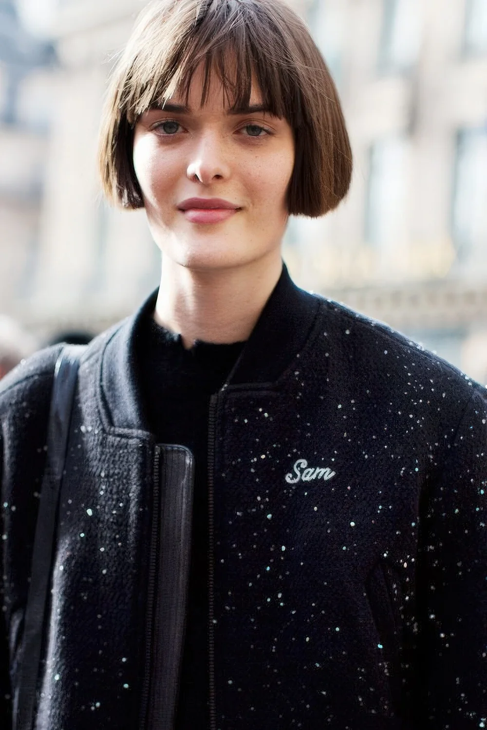 Classic ear-length brunette bob with wispy bangs.
