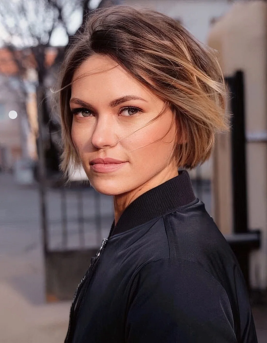 Brunette ear-length bob with blonde balayage and messy volume.