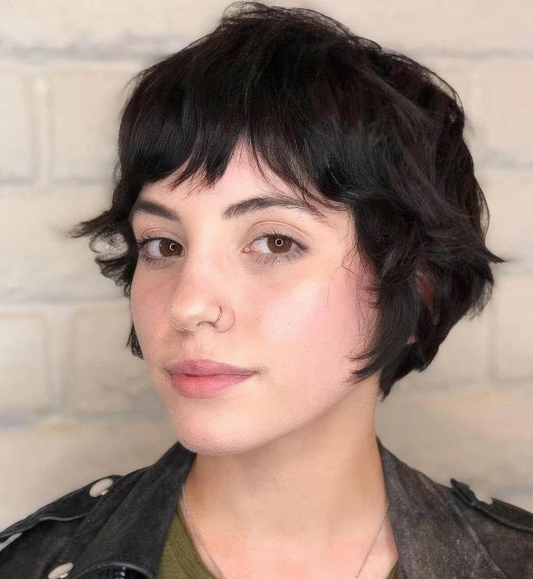 Shaggy black ear-length bob with bottleneck bangs and waves.