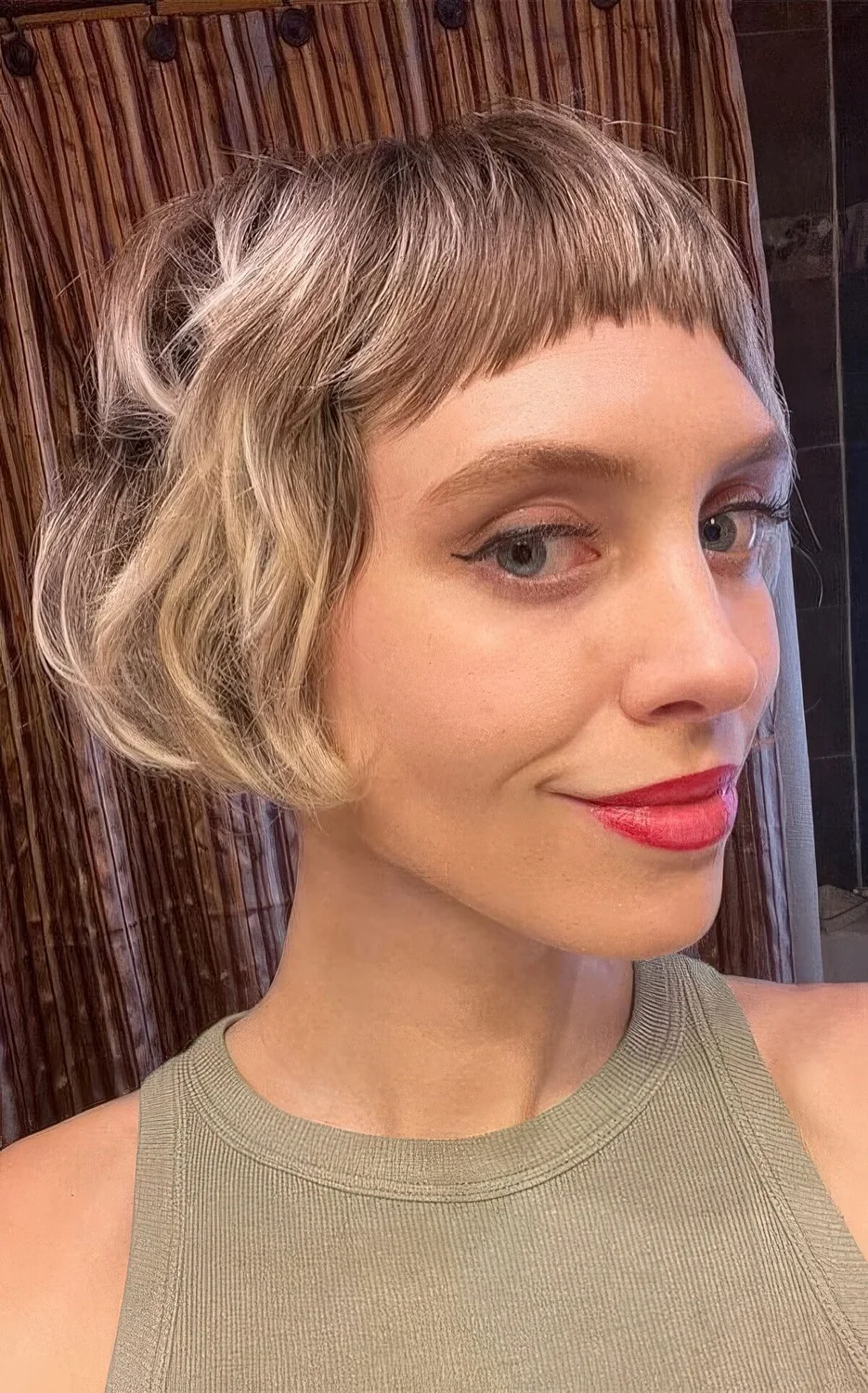 Ear-length bob with blodne balayage and baby bangs plus messy waves.