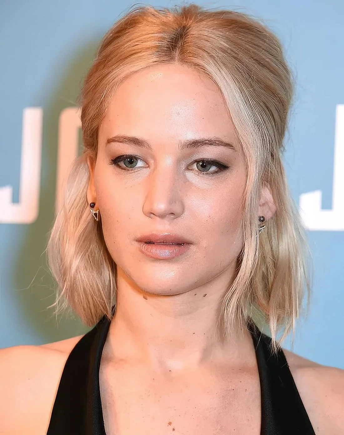 Blonde midi bob styled as a half updo, with some face-framing hair.