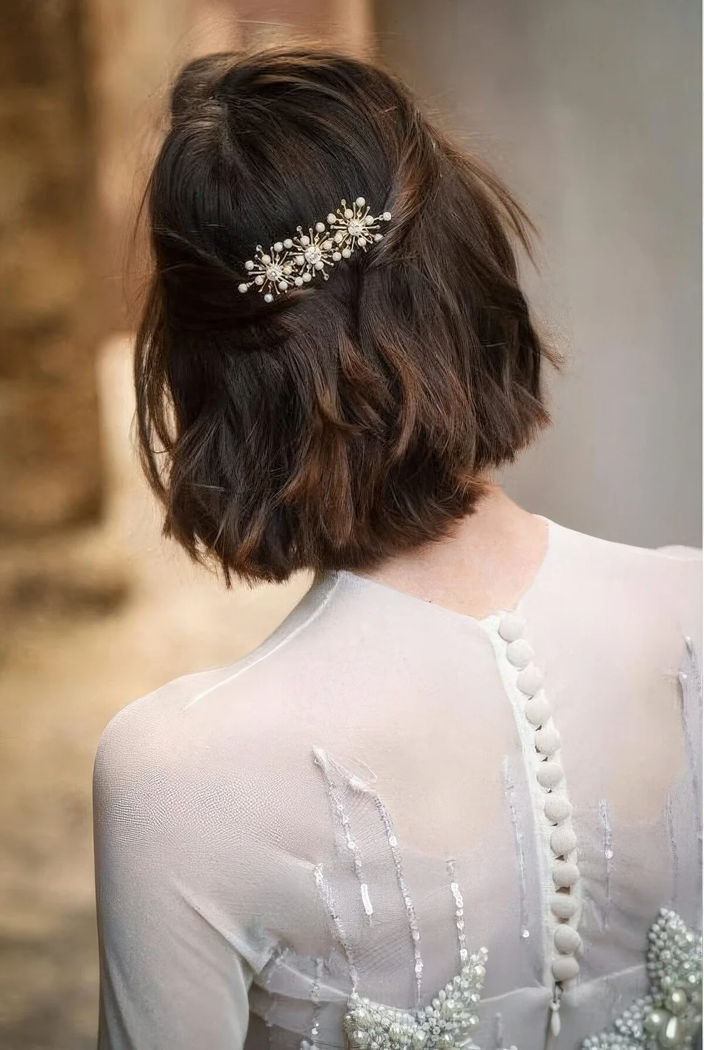 Long bob with wavy hair, styled as a half updo, with a beautiful rhinestone hair barrette.