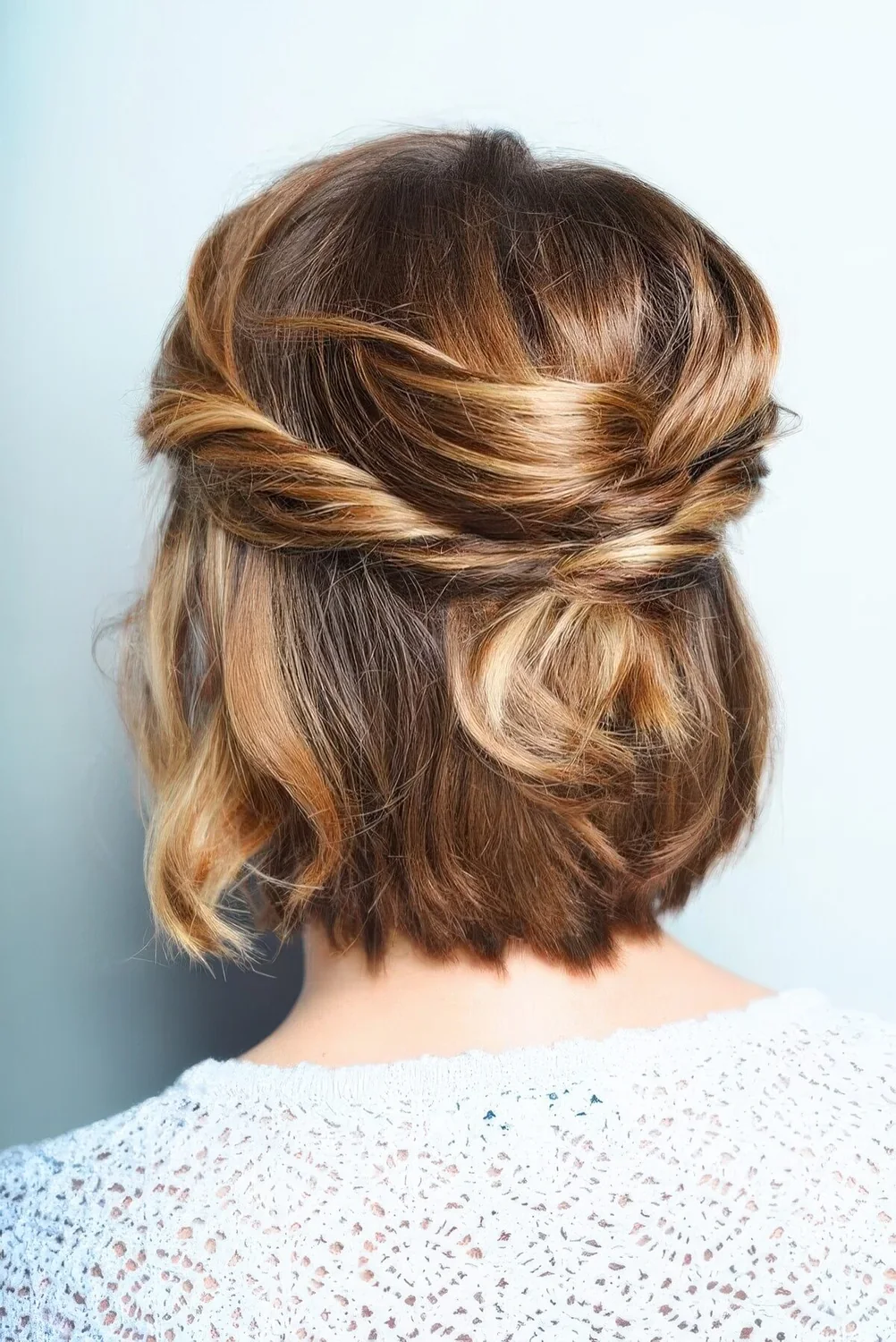 Half updo with a bump on top and twisst and waves.