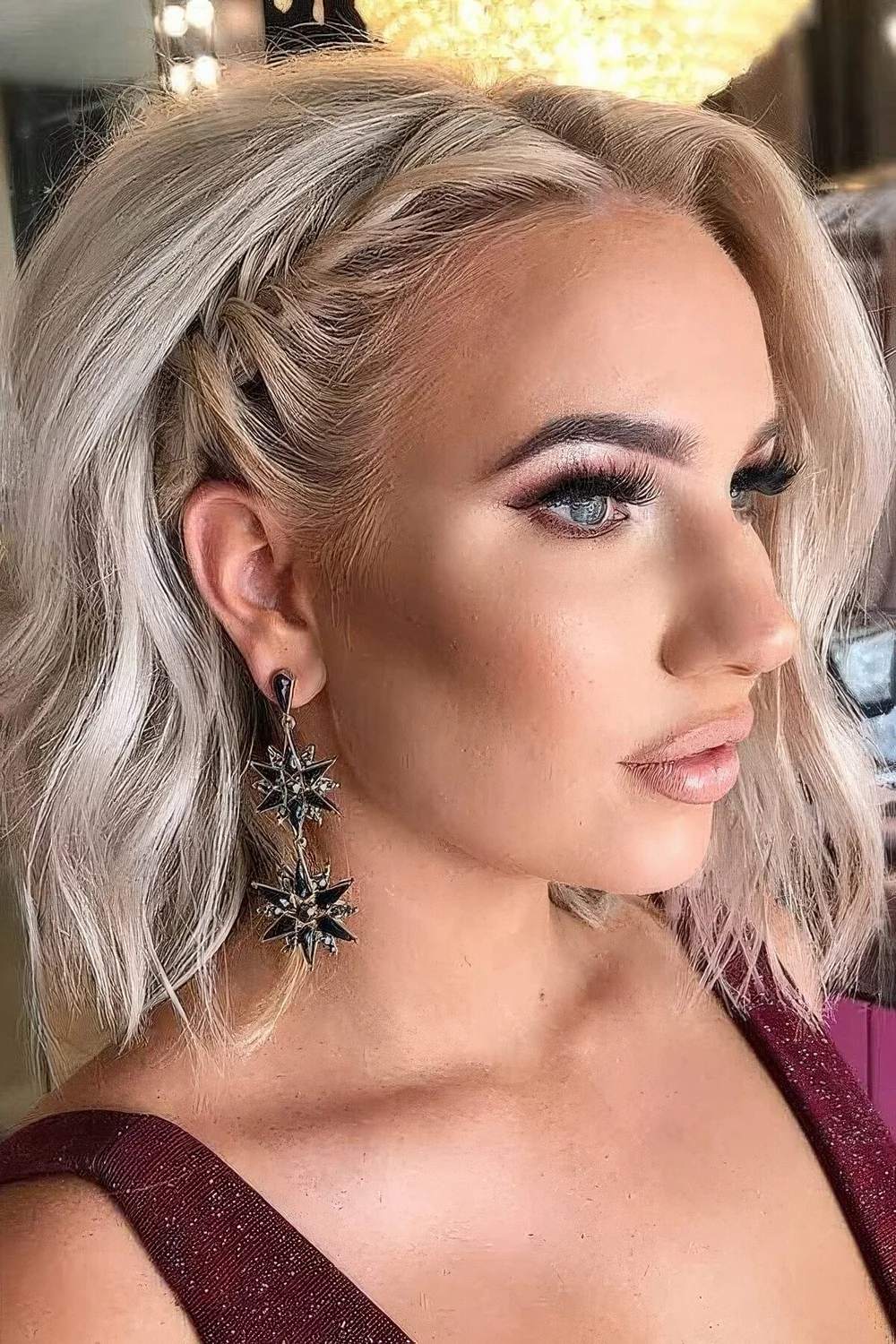 Long blonde bob with a side braid, volume and waves.