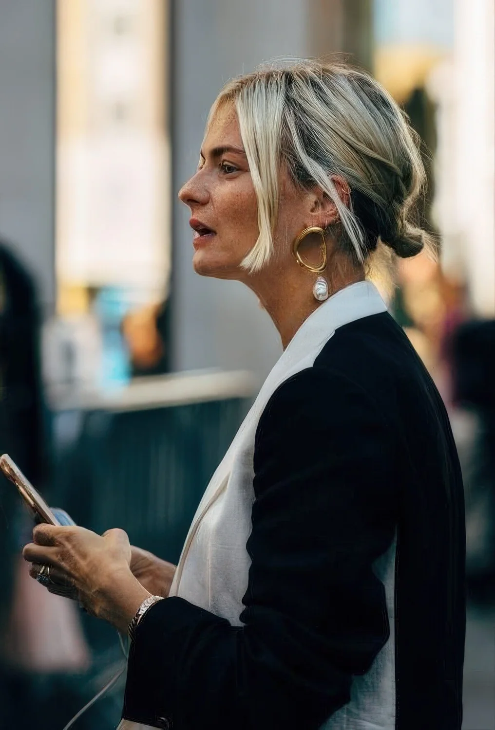 Blonde bob styled with a low bun and some volume on top plus some face-framing hair.