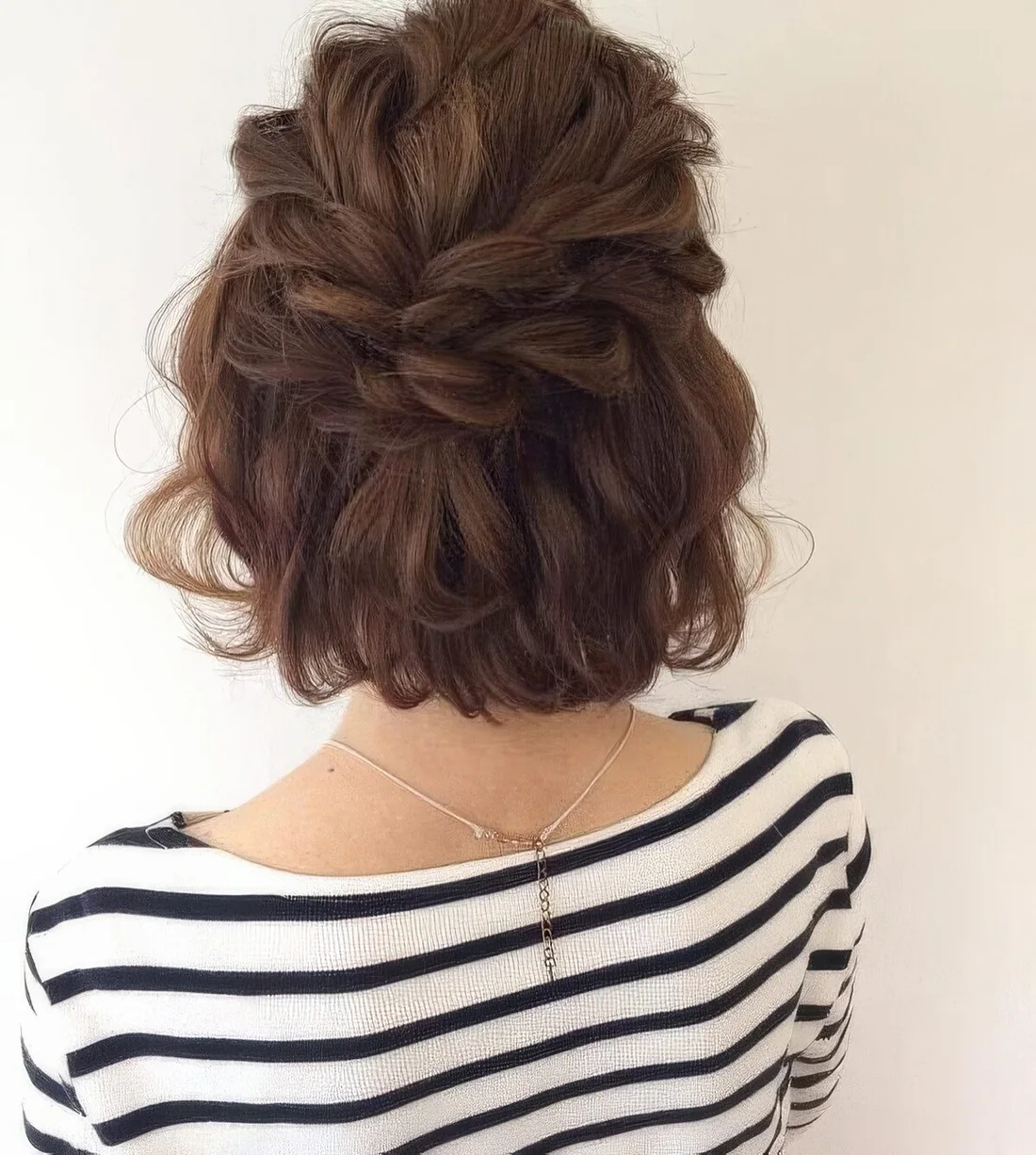 Messy and voluminous half updo with a loose double braid, a wavy top and waves down.