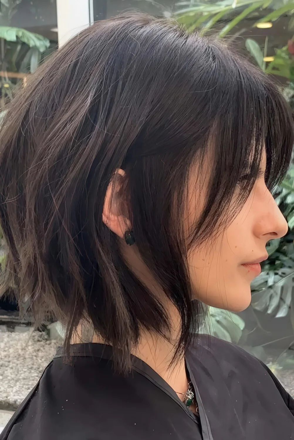 Choppy dark brunette bob with bangs and slight waves.