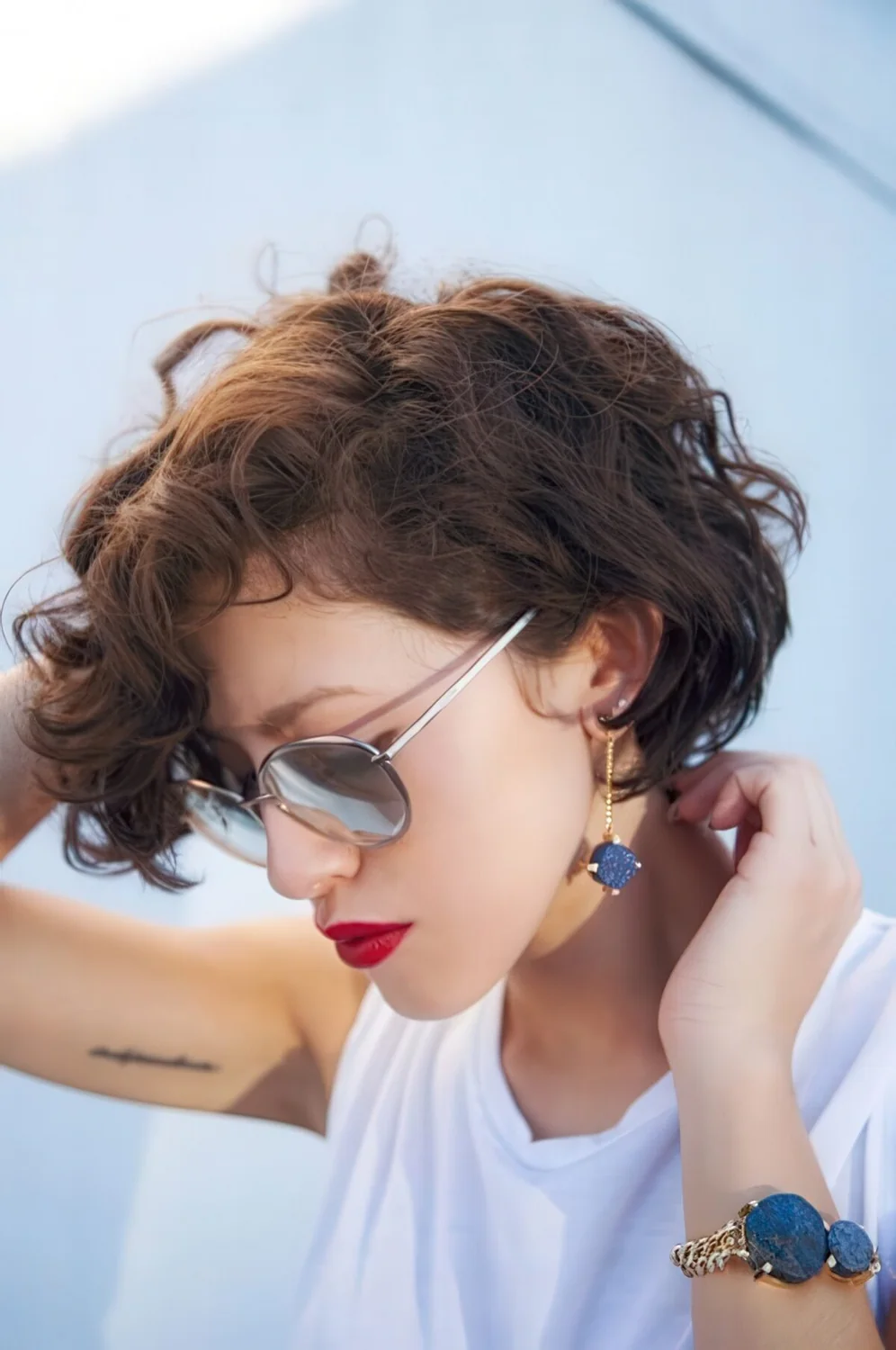 Short brunette bob done on naturally wavy hair, with side part.