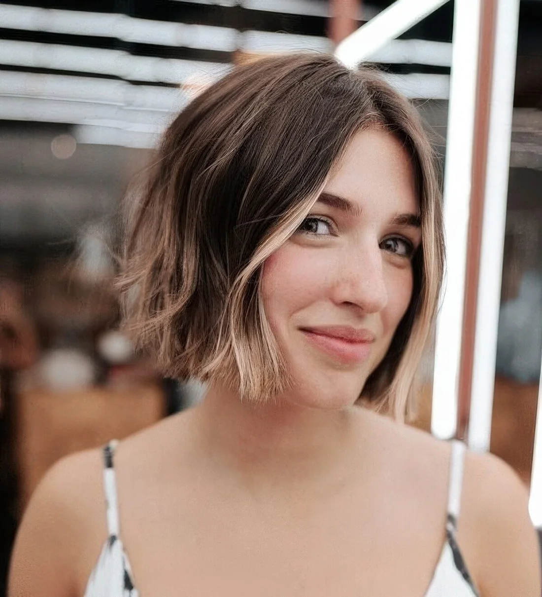Brunette jaw-length bob with a bit of blonde balayage and money piece.