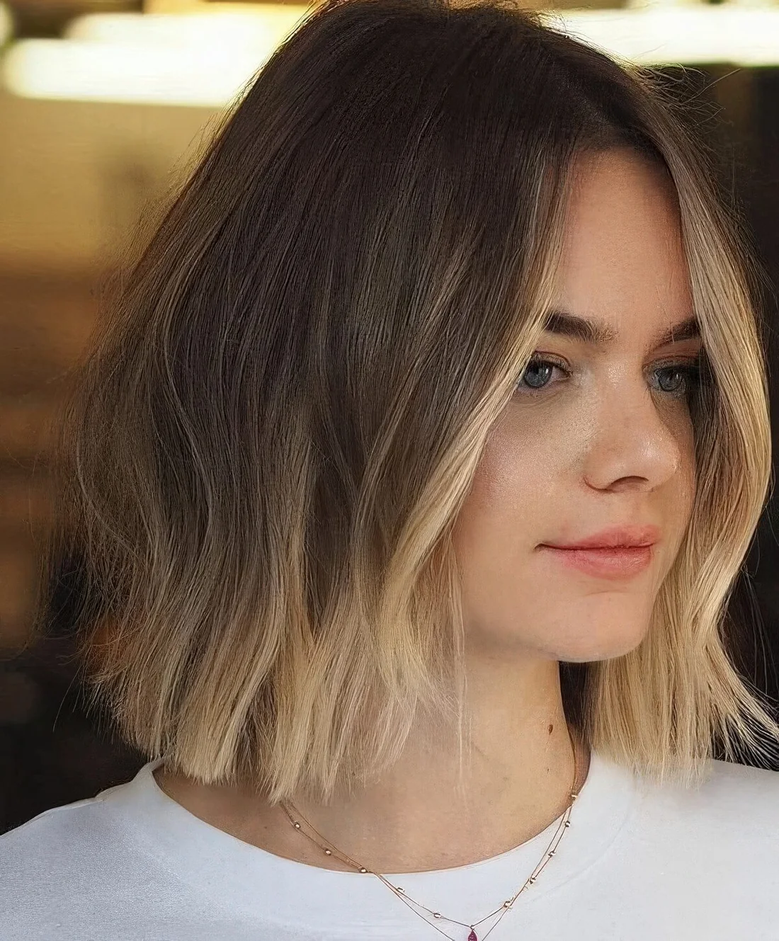 Brunette long bob with a blonde ombre touch and a blonde money piece highlights the face.