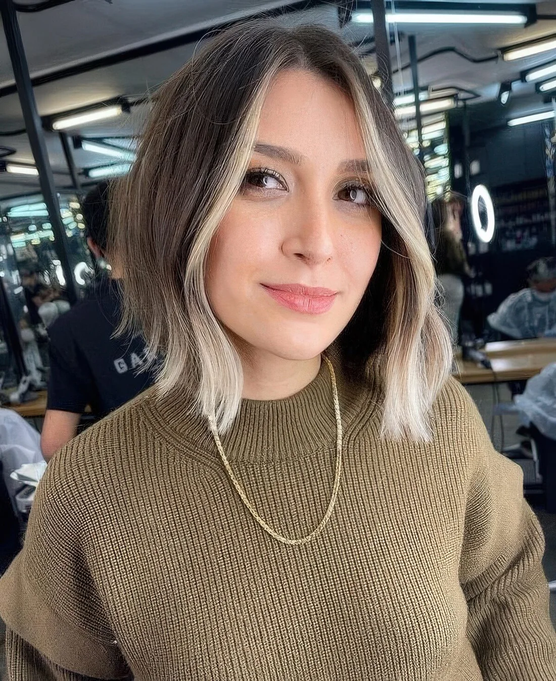Light brunette long bob with a blonde money piece and waves.
