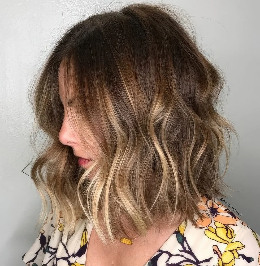 Medium shaggy bob haircut with blonde balayage to give the hair a dimension.