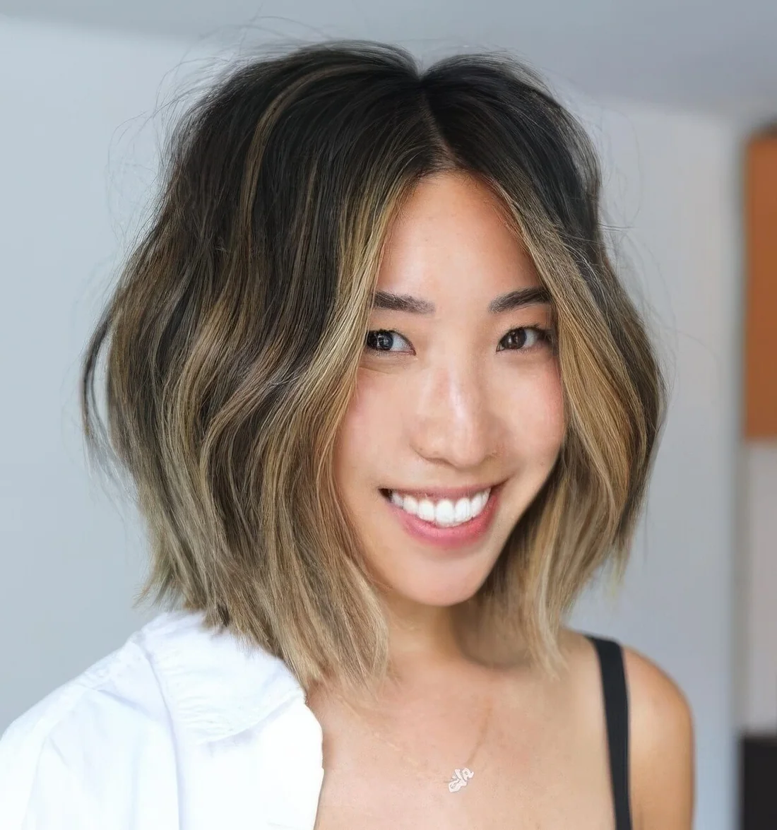 Brunette long bob with blonde balayage and a money piece plus waves.