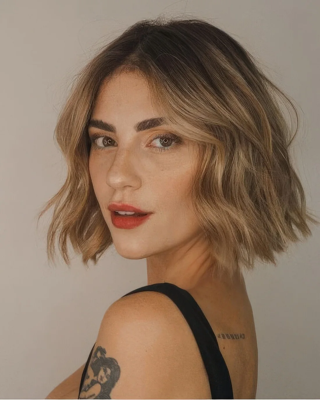 Relaxed bronde warm shaded midi bob with waves and a darker root.