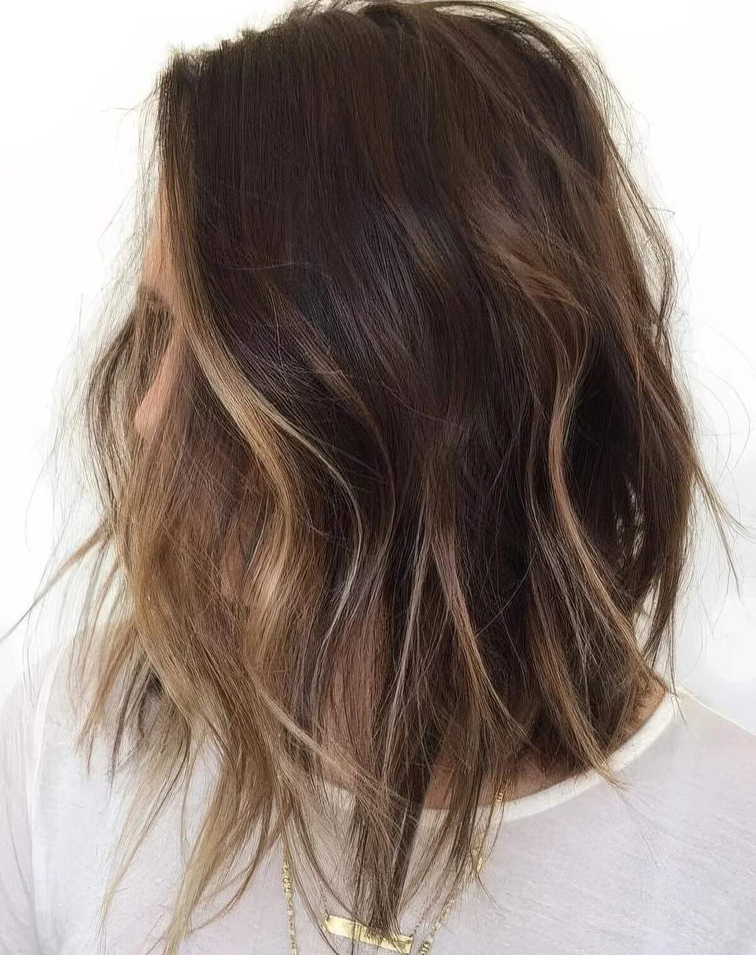 Shaggy brunette bob with face-framing bronde balayage to highlight the face.