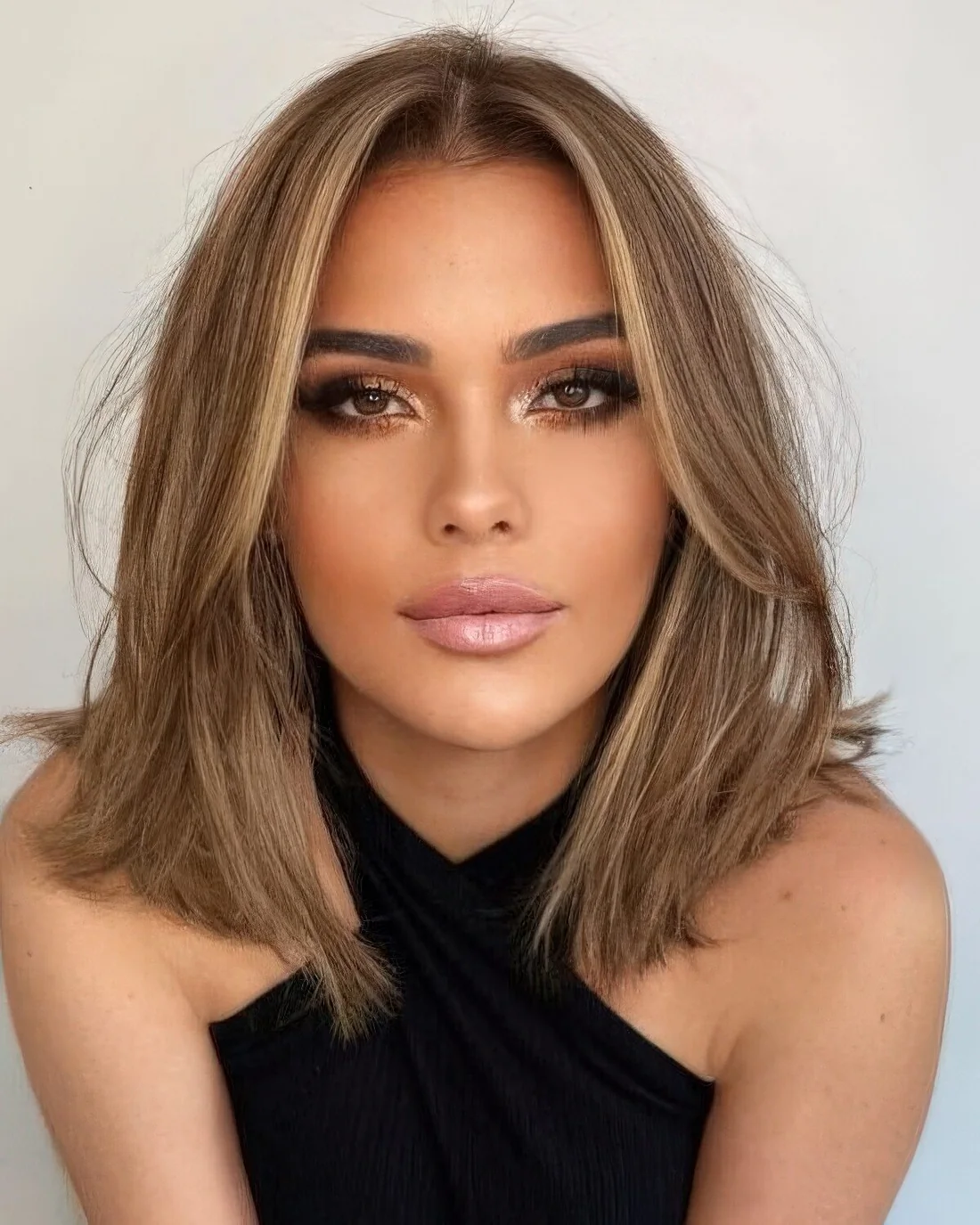 Soft bronde outgrown bob with a bit of blonde highlights and soft curtain bangs dyed blonde, too.
