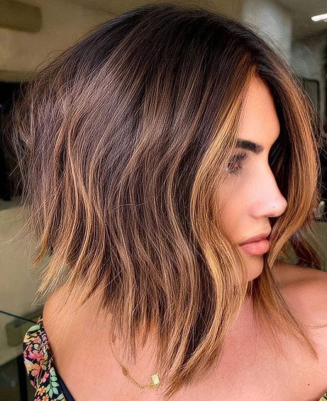 Line dark brunette bob with caramel balayage and a money piece plus messy waves.