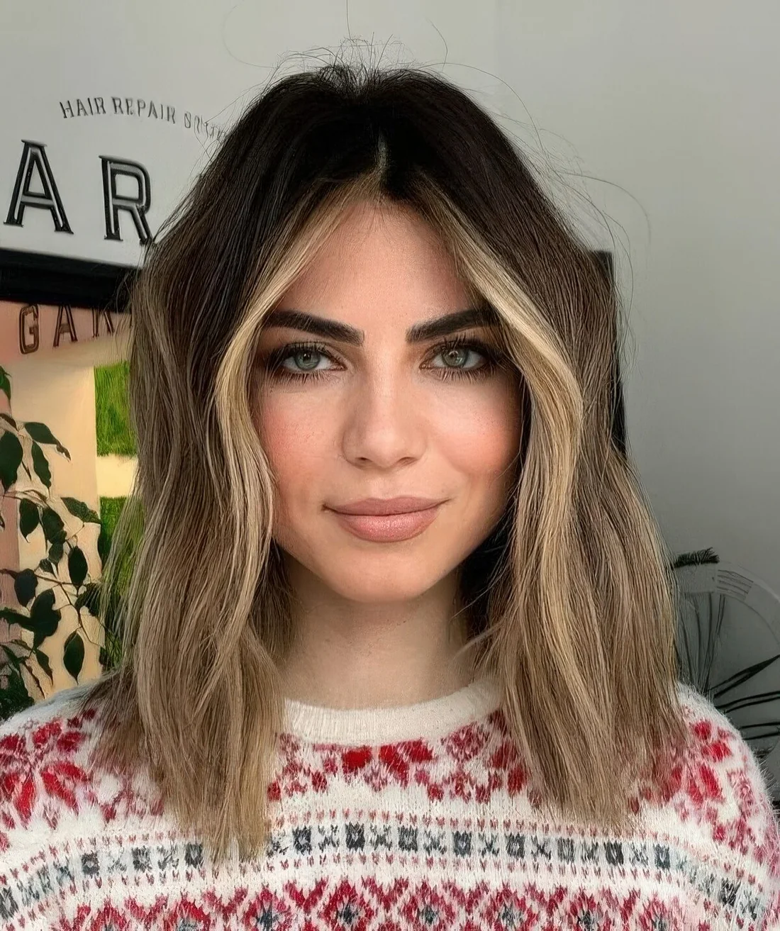Dark brunette hair with light sunkissed balayage and face-framing highlights.