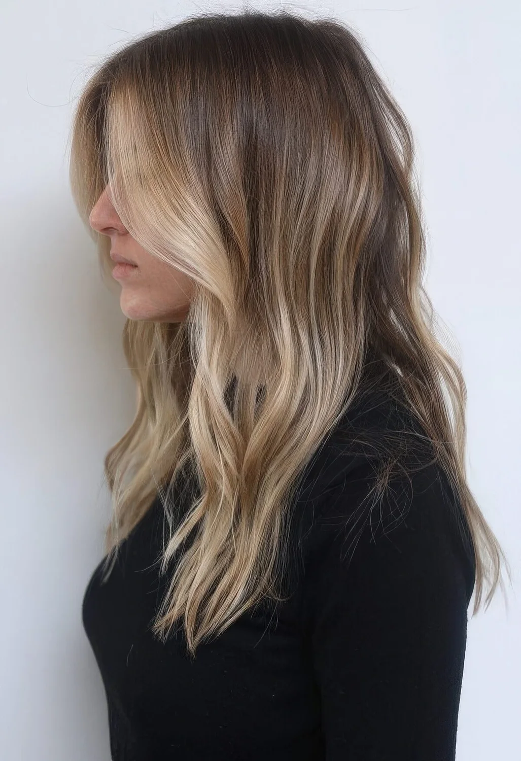 Light brunette hair with sunkissed blonde highlights and with waves.