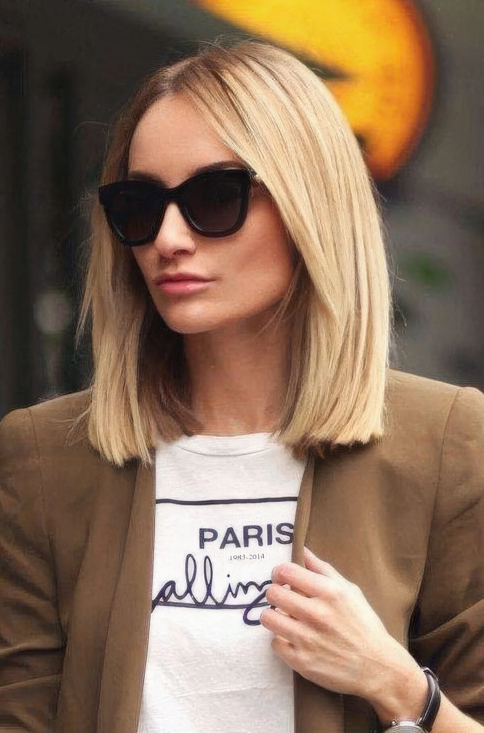 Classic blonde clavicut with sleek and voluminous hair and face-framing layers.