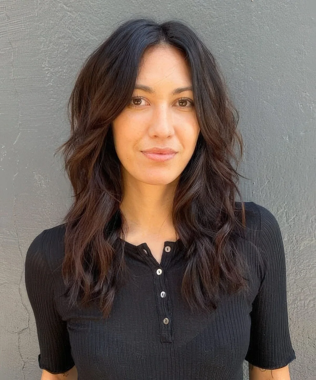 Dark brown long shaggy haircut with center part and face-framing layers.