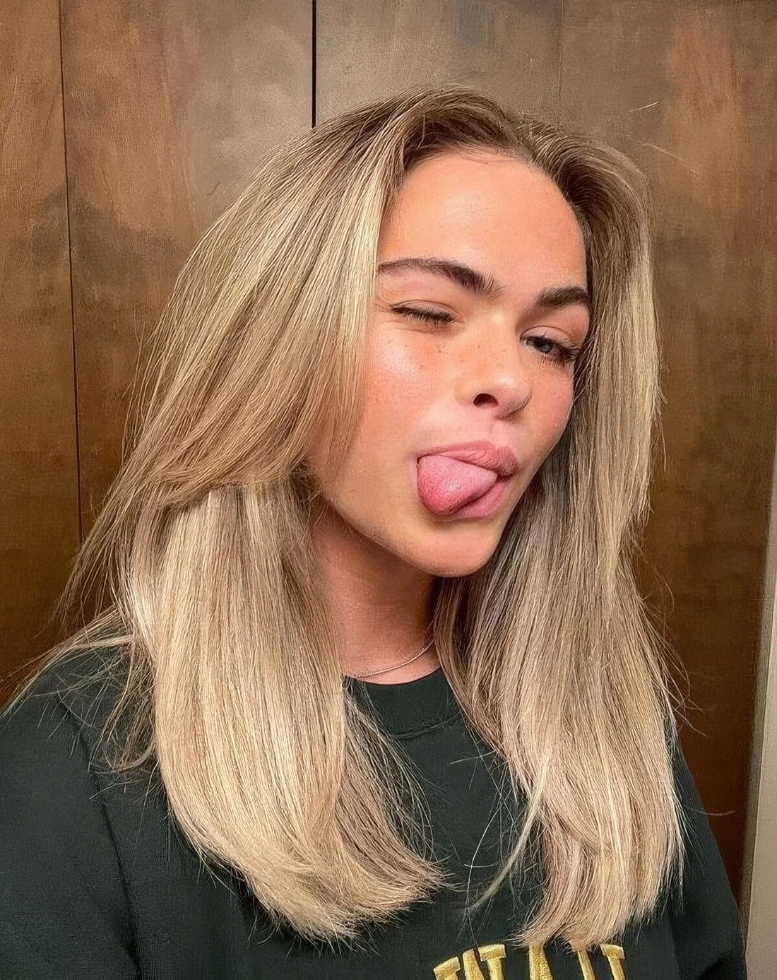 Medium-length blonde hair with face-framing layers and middle part.