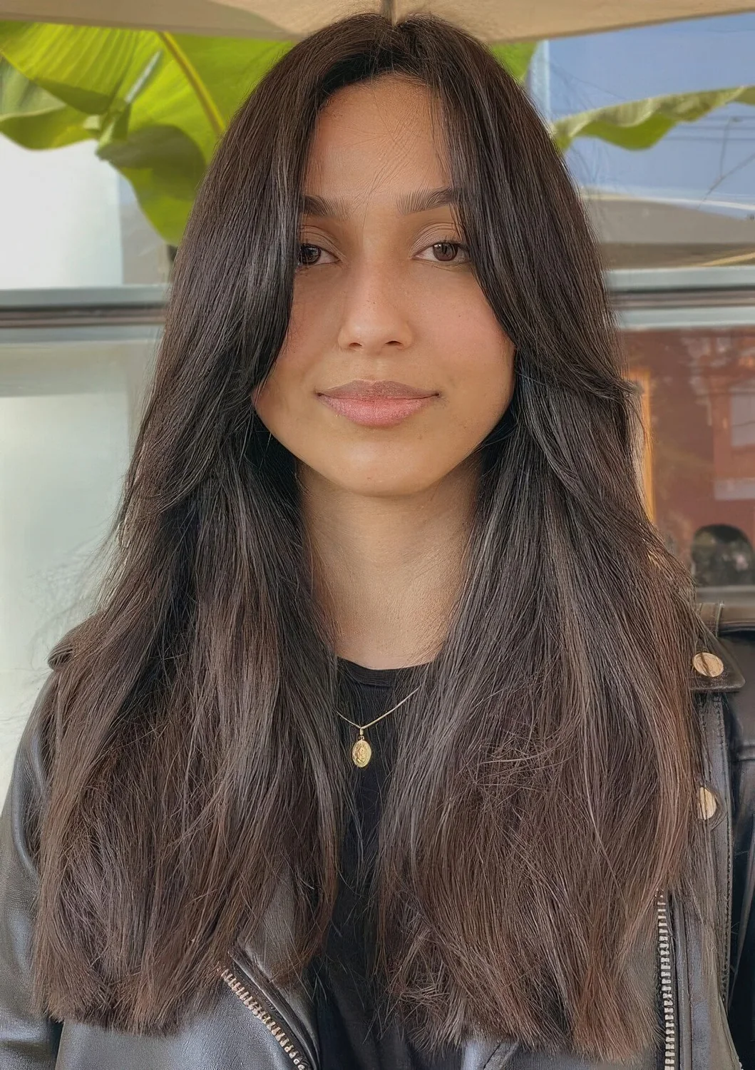 Long dark brunette hair with layers including face-framing ones, with center part.