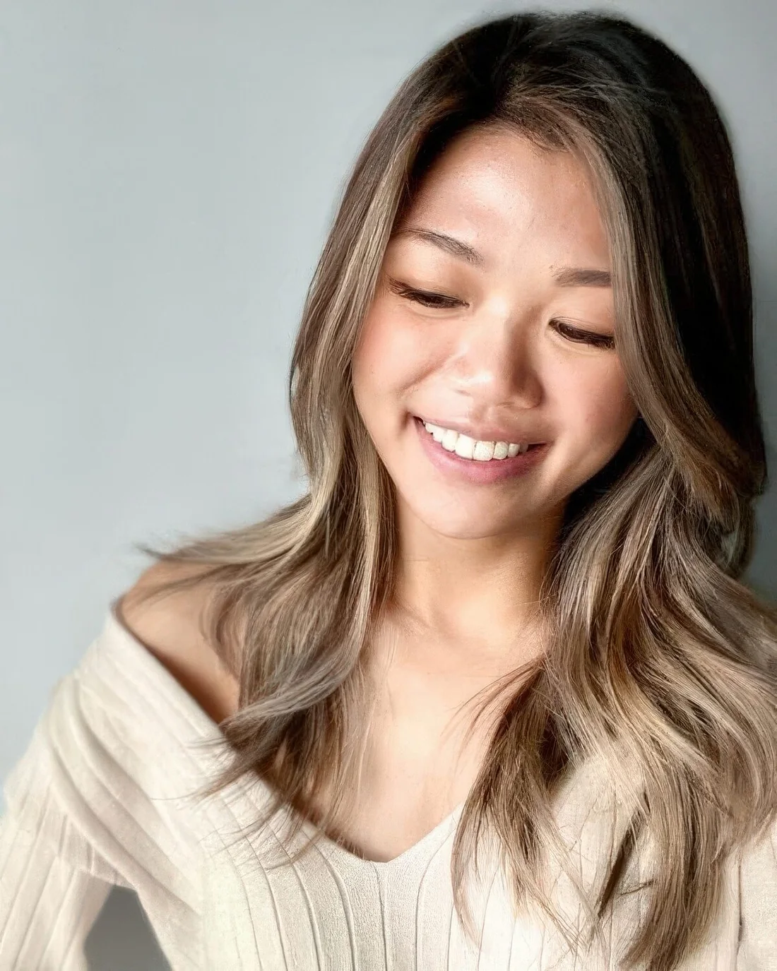 Long and lovely brunette hair with mushroom brown balayage and side part, with face-framing layers.