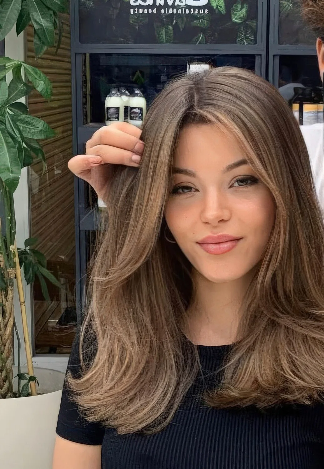 Long brunette hair with caramel highlights and face-framing layers.