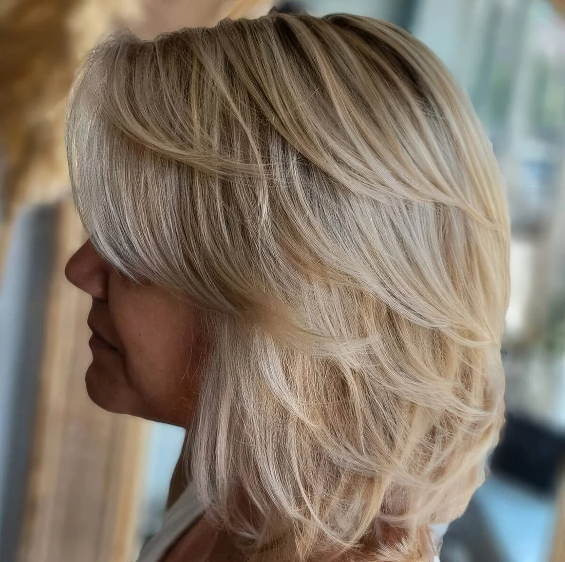 Feathered long blonde bob with side bangs.