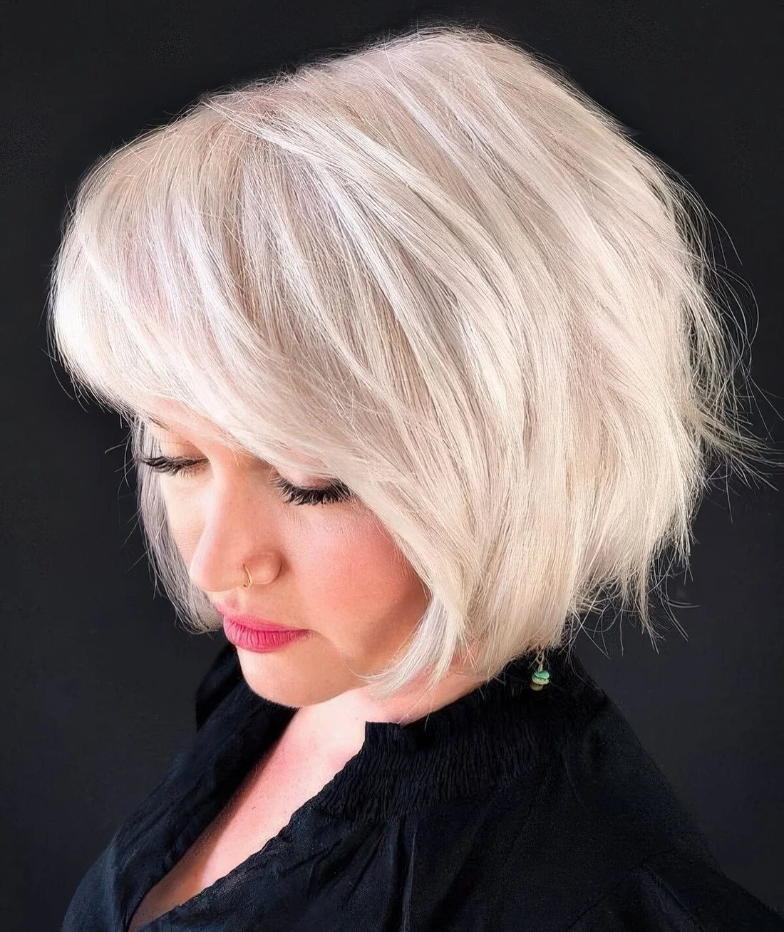 Platinum blonde feathered bob with side bangs.