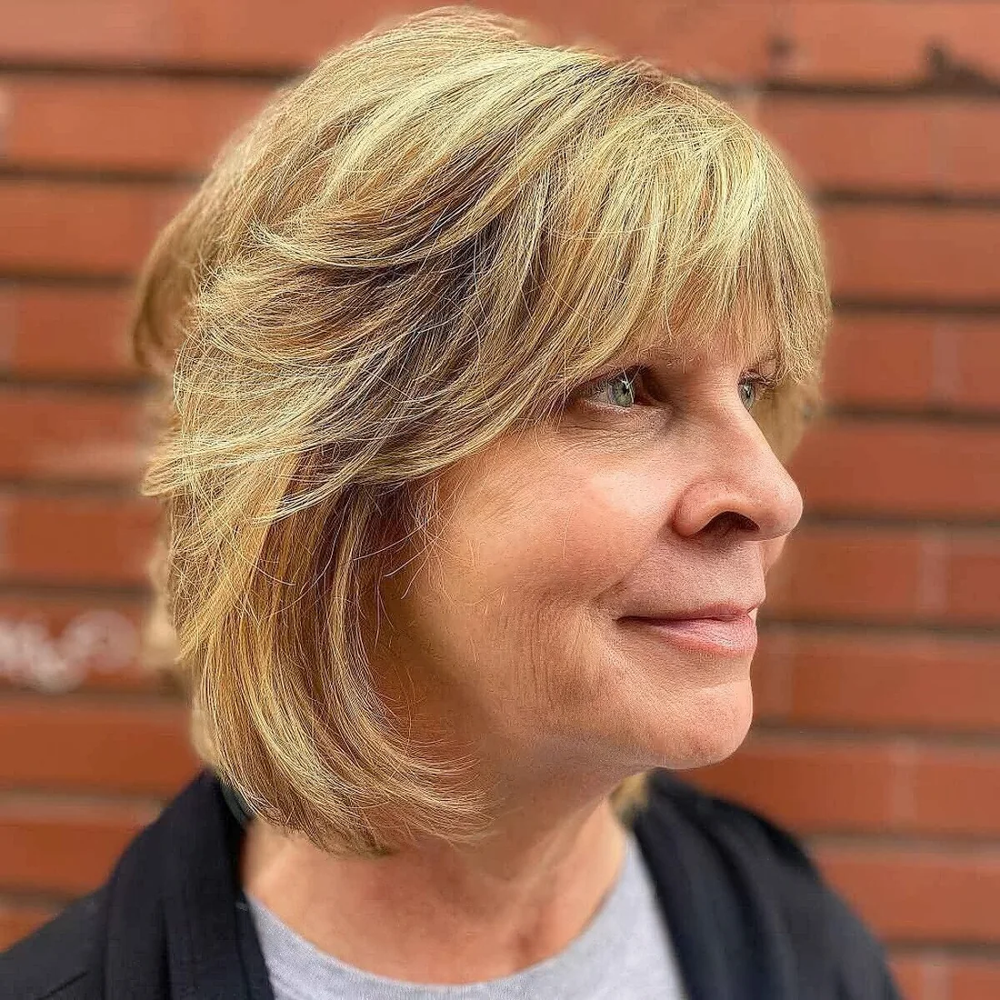 Long bob with feathered layers and bangs.