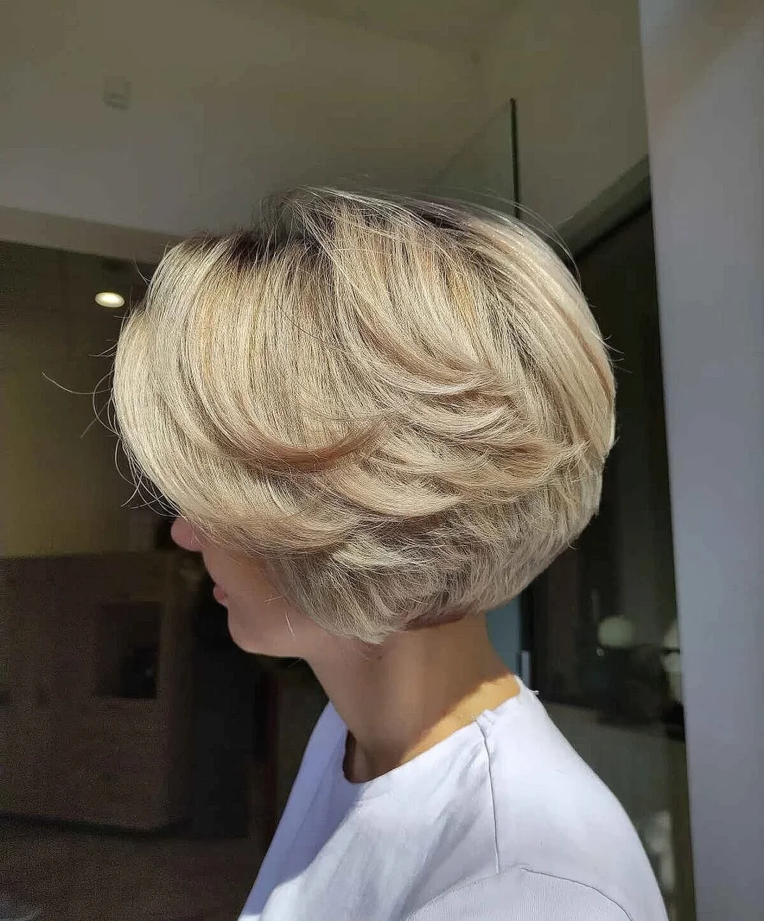 Short feathered bob haircut done in blonde.