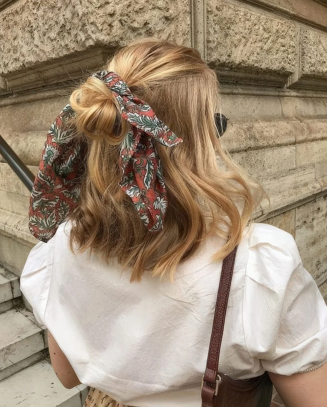 Photo showing midi bun half updo, with the hairstyle clearly visible.