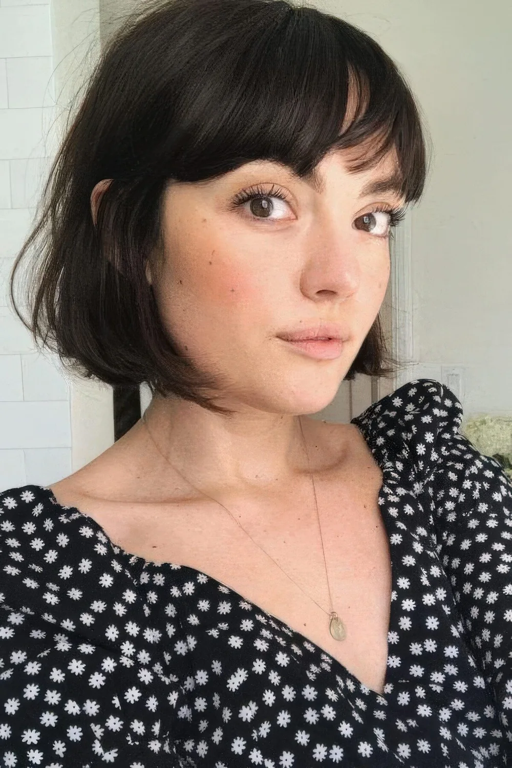 Black French bob with long bangs and texture.