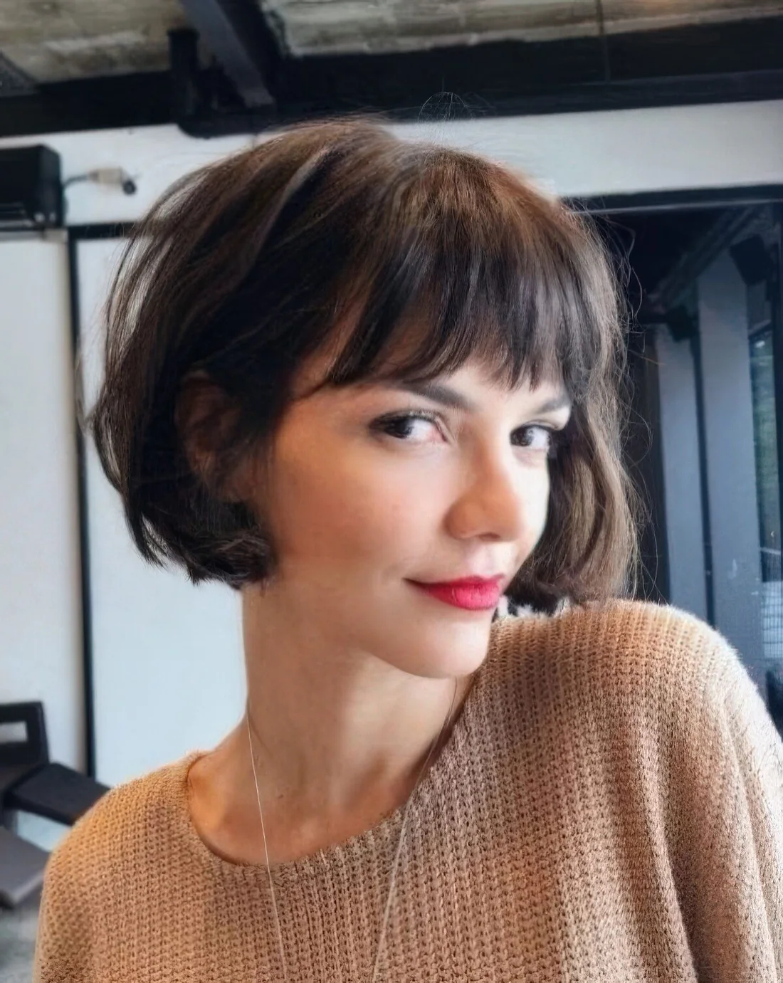Brown French bob with bangs and waves.