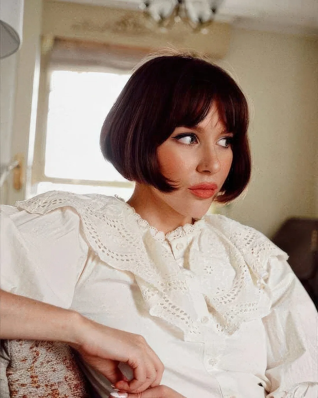 Dark brown jaw skimming length French bob with curtain bangs.