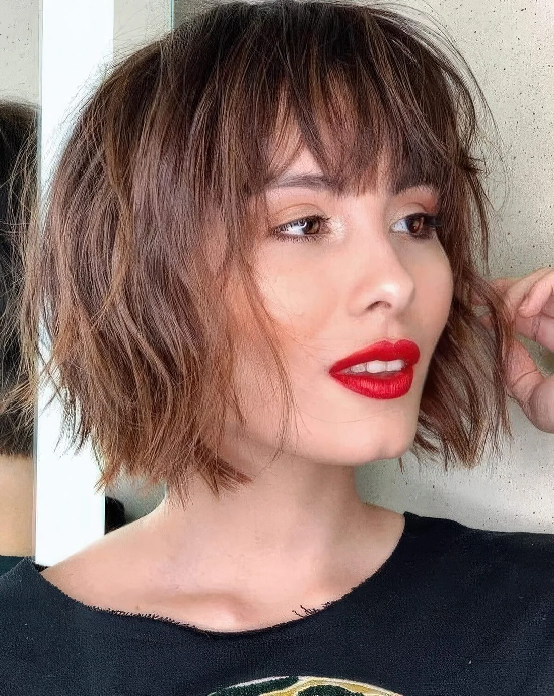 Messy and textural short brunette bob with layers and fringe.