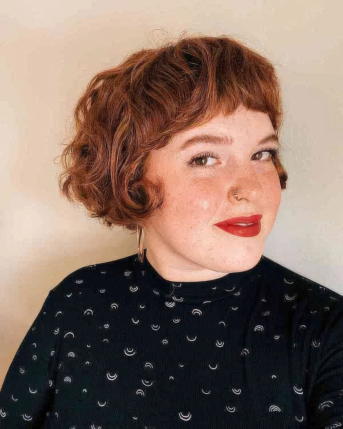 Ginger French bob on curly hair, with short bangs.