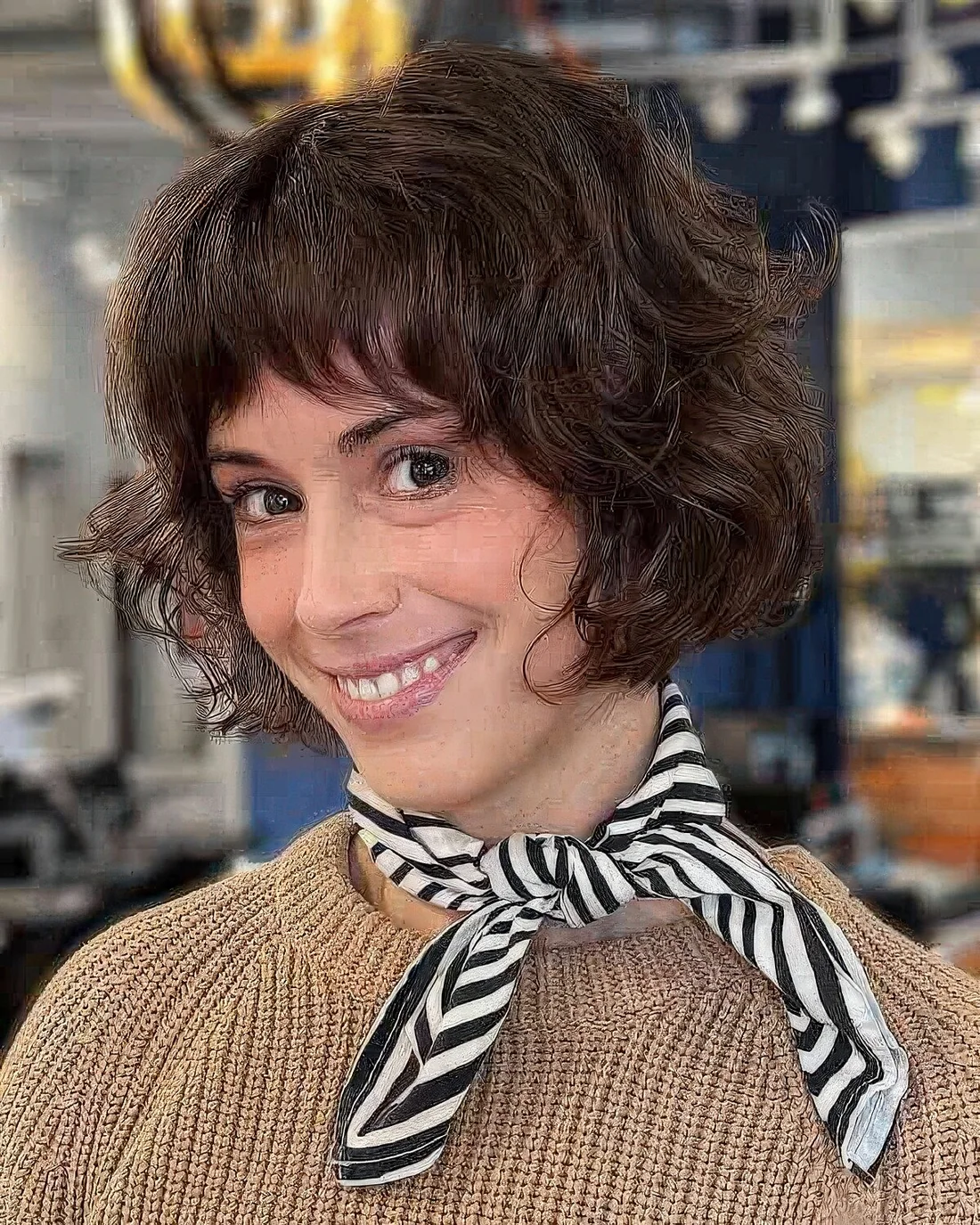 Short stacked French bob with feathred bangs and curls.
