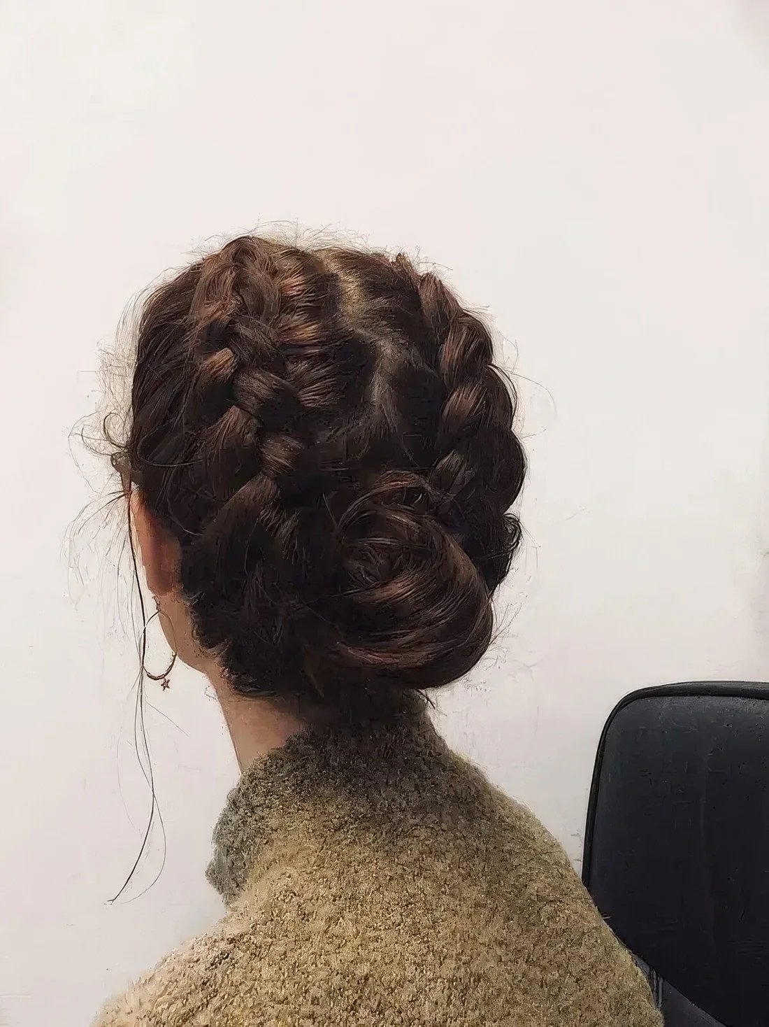 Braided updo with a wrapped bun and chunky braids on the sides of the head.