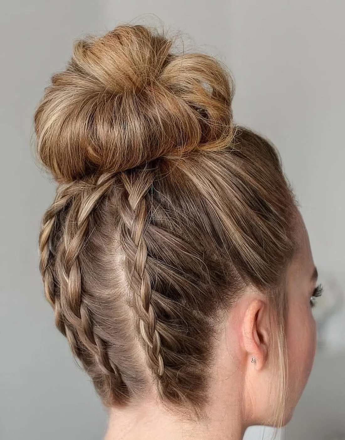 Top ballerina knot made more whimsical with three French braids are a very creative hairstyle.