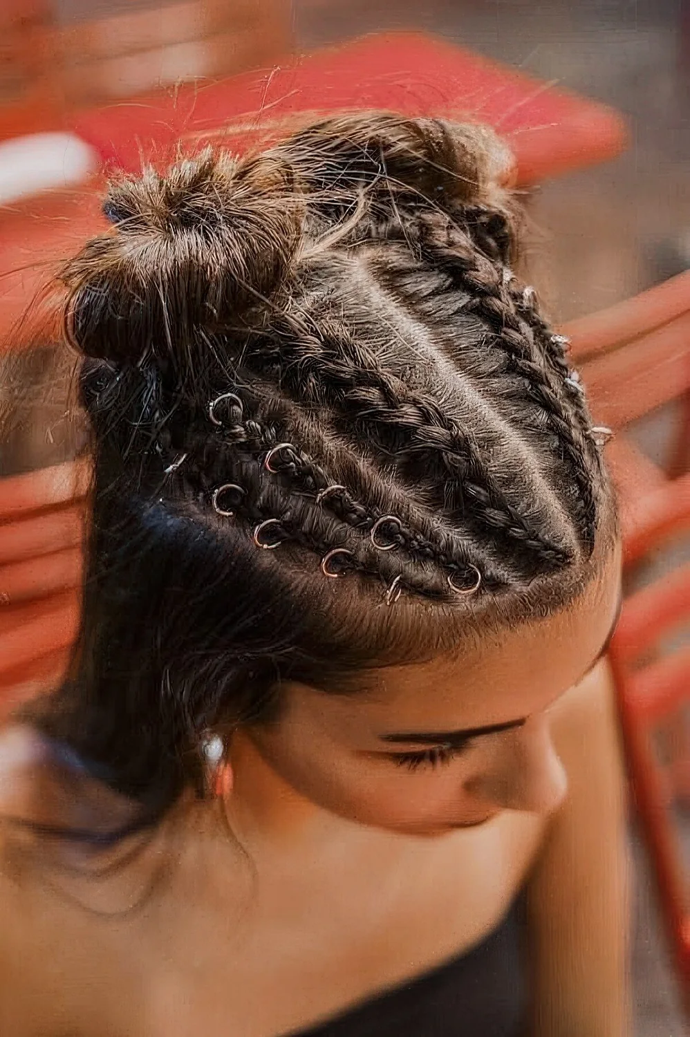 Creative half updo with multiple French braids with hair piercings, space buns and hair down.
