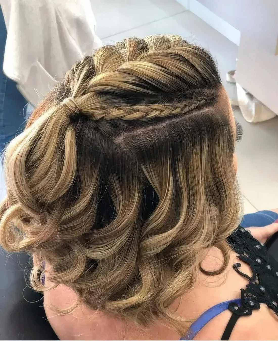 Half updo with a large and two small French braids on top an waves down.