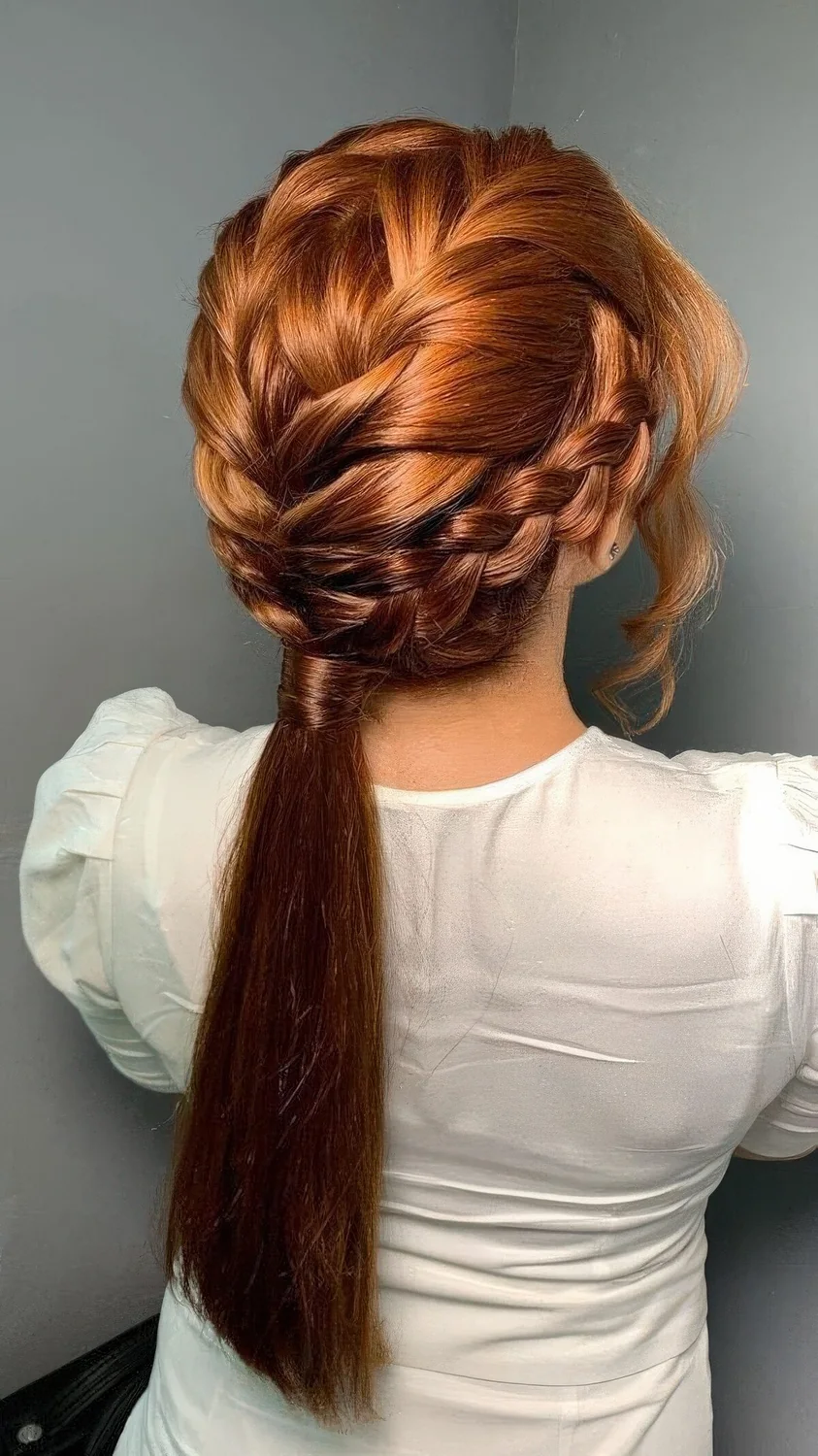 Complicated look with two top and two side French braids into a long low ponytail and waves framing the face.