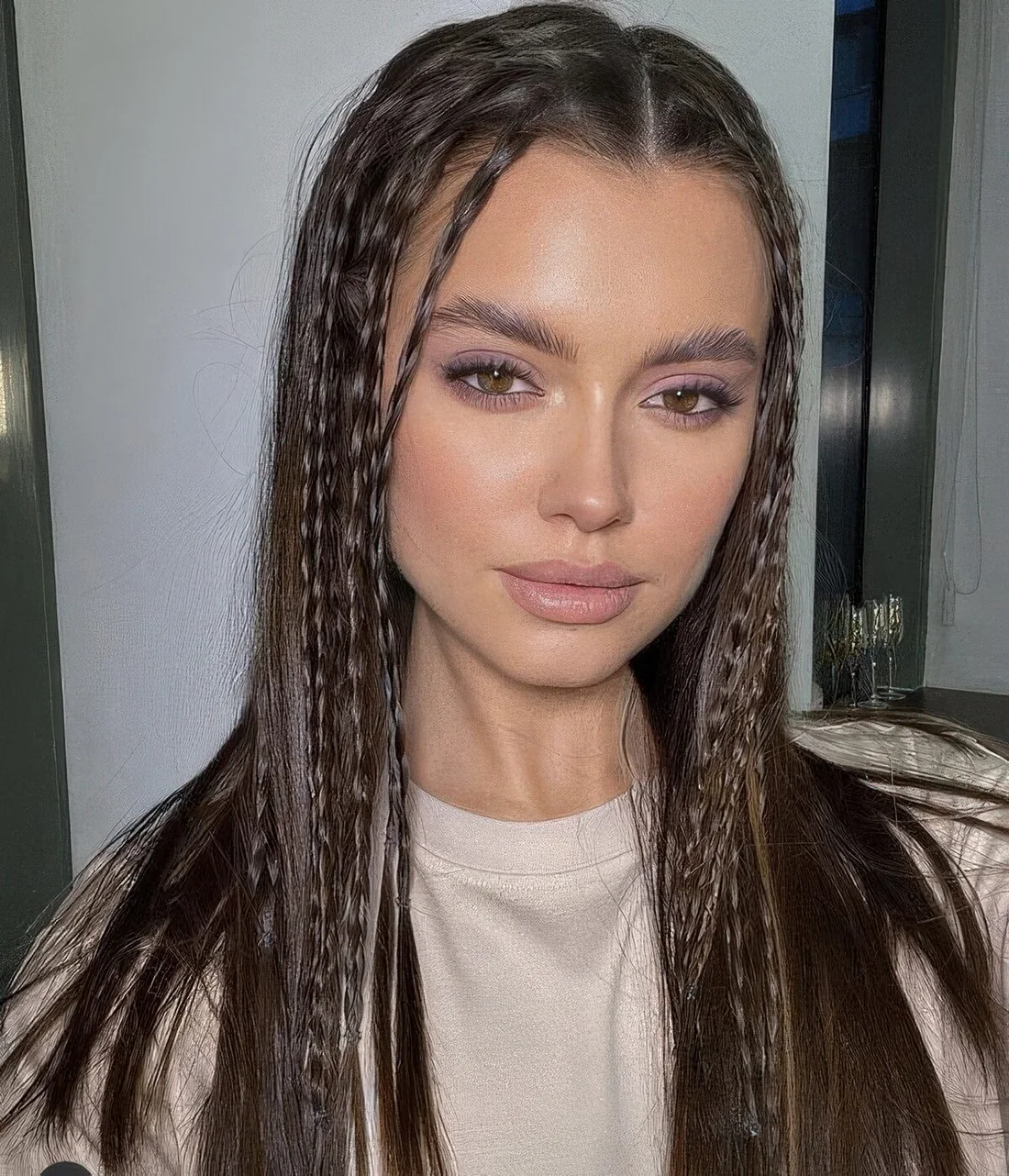 Creative modern hairstyle with little French braids around the face and straight hair down.