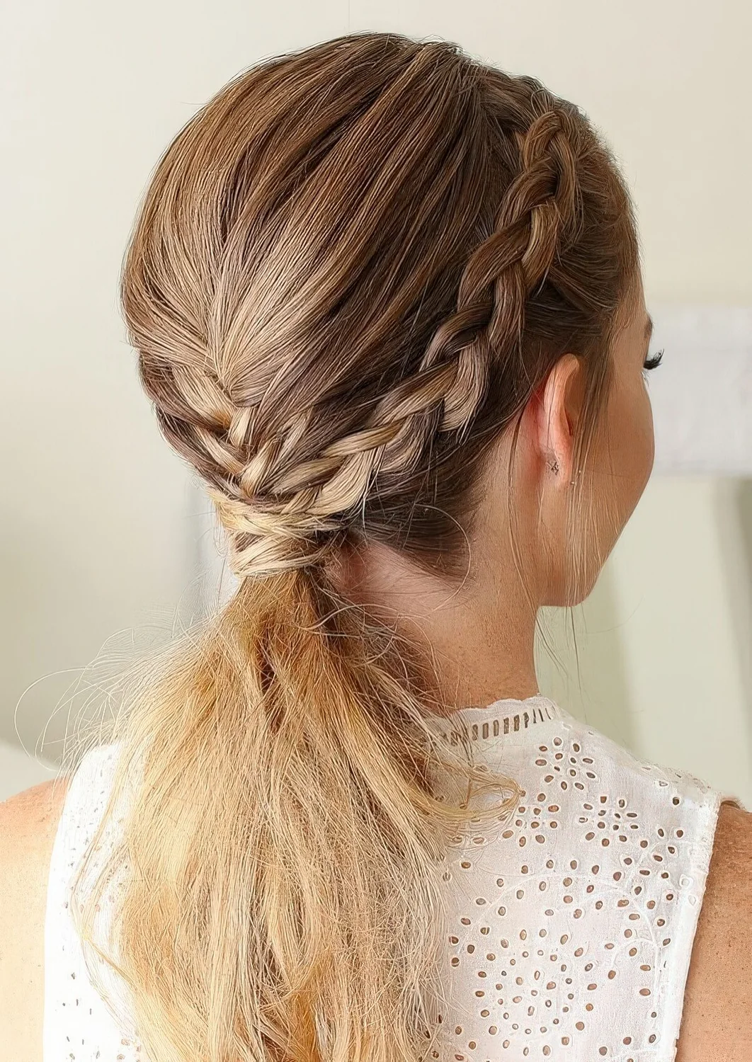 Creative rustic hairstyle with side French braids and a center one into a ponytail.