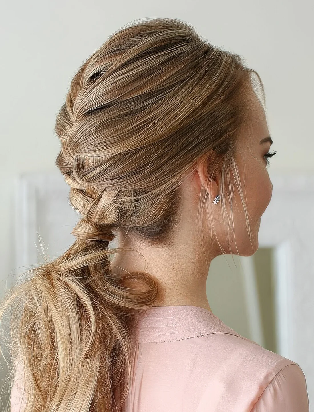 French braid into a low ponytail, with a bump on top.