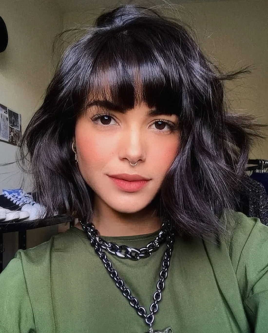 Black messy wavy chin-length bob with fringe bangs.